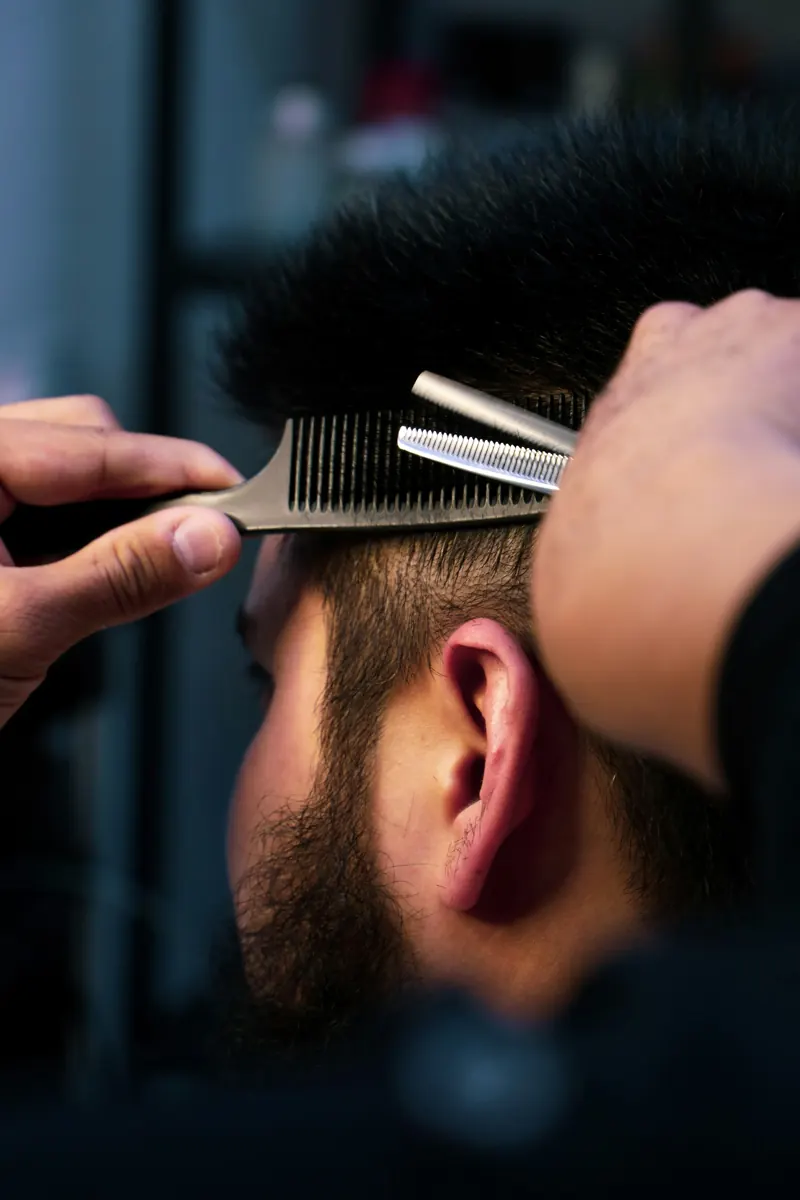 Thinning shears and a comb lifting hair at the back of the head